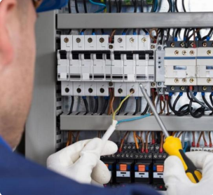 Eletricista realizando manutenção em quadro de disjuntores industrial